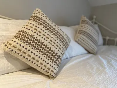 two pillows sitting on top of a bed at Bear cottage in Brecon