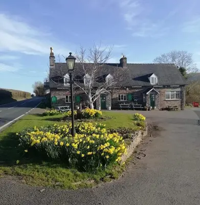 a house with a street light and yellow flowers at The Old Ford inn in Llanhamlach