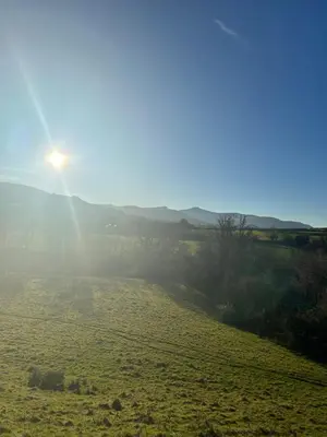 a field with the sun shining on the horizon at The Old Ford inn in Llanhamlach