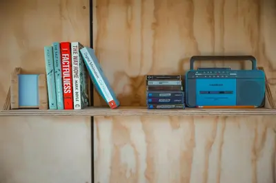 a shelf with books and a radio on it at Hydra in Llangollen