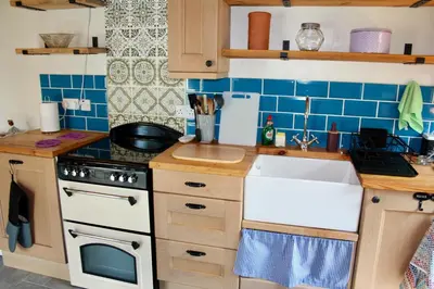 a kitchen with a white sink and blue tiles at Severn Up in Newtown