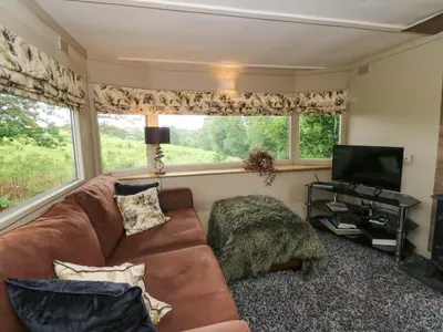 a living room with a couch and a television at Gwybedog in Llanwrda