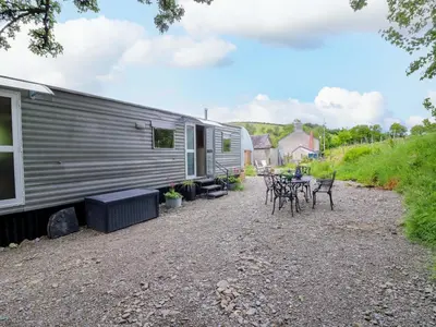 a trailer with tables and chairs in front of it at Gwybedog in Llanwrda