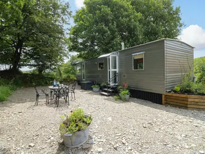 a small green trailer with a table and chairs at Gwybedog in Llanwrda