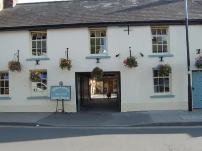 a white building with a sign in front of it at Borderers Inn in Brecon