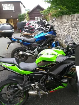 a row of motorcycles parked next to a stone wall at Borderers Inn in Brecon