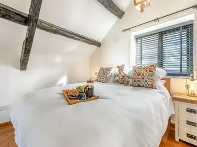 a bedroom with a white bed with a tray on it at Coach House - Uk49793 in Cribyn