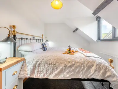 a white bedroom with a bed and a desk at Cwtch Honey - Uk49792 in Cribyn