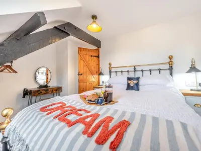 a bedroom with a bed with a tray of food on it at Cwtch Honey - Uk49792 in Cribyn