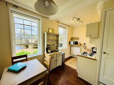 a kitchen with a table and a stove top oven at English Bridge Court in Shrewsbury