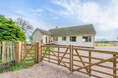 a house with a wooden fence in front of it at Pear Tree Cottage in Shrewsbury