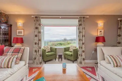 a living room with a couch and chairs and a window at Pear Tree Cottage in Shrewsbury
