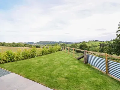 a garden with a fence and green grass at Charollais in Oswestry