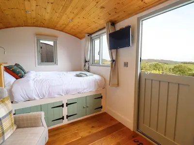 a bedroom with a bed and a large window at Charollais in Oswestry