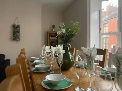 a table with glasses and bowls and a vase with flowers at Llangollen High Street 4 bedrooms Sleeps 12 in Llangollen