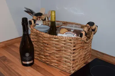 a basket of wine and bread and a bottle of wine at Awel Mor 3 Luxury Apartment in Aberystwyth