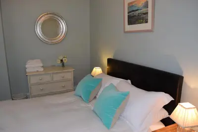 a bedroom with a bed with blue and white pillows at Awel Mor 3 Luxury Apartment in Aberystwyth