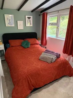 a bedroom with a large red bed with red pillows at Robins' Rest - 22 Caer Beris Luxury Lodge Park NEW Sleeps 6 Riverside Reteat in Builth Wells