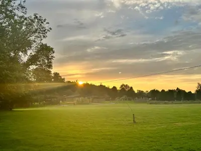a green field with the sun setting in the distance at Robins' Rest - 22 Caer Beris Luxury Lodge Park NEW Sleeps 6 Riverside Reteat in Builth Wells