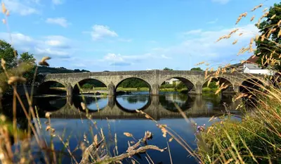 a stone bridge over a river with reflections in the water at Robins' Rest - 22 Caer Beris Luxury Lodge Park NEW Sleeps 6 Riverside Reteat in Builth Wells