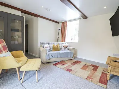 a living room with a couch and a chair at 1 Y Llew in Llandinam