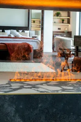 a fire in the middle of a room with a bed at Ty Glyn Hotel in Ciliau-Aeron