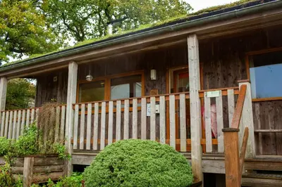 a wooden house with a porch and a fence at Robins Perch Eco Lodge Apartment Lampeter in Lampeter