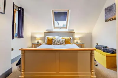 a bedroom with a large bed with yellow pillows at 2 Bed in Pentre Bach oc-b30875 in Pentre-bâch