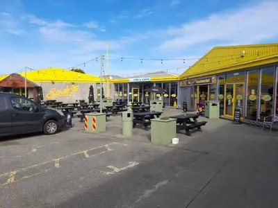 a parking lot with picnic tables in front of a building at Sher, My Happy super static -2026 Award winner in Llanddwywe