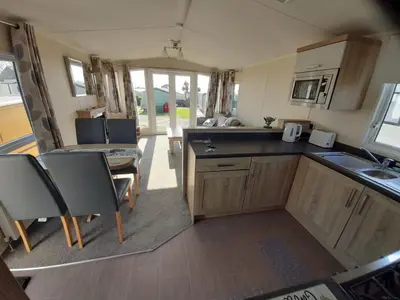 an rv kitchen with a sink and a table at Sher, My Happy super static -2026 Award winner in Llanddwywe