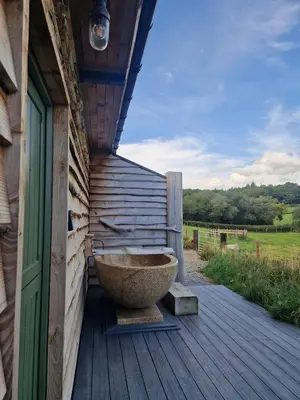 a large stone bowl sitting on a wooden deck at Birch Banc Retreats - Bedw Cabin