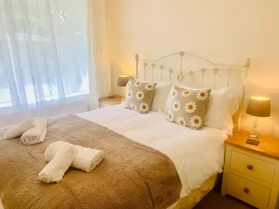 a bedroom with a bed with two towels on it at 3 Riverside Bungalows in Llanbedr