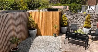 a wooden fence with a bunch of potted plants at Kookaburra Cottage in Brecon