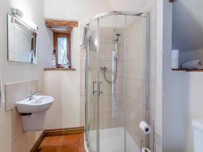 a bathroom with a shower and a sink at Wern Farm Barn in Cwmdu