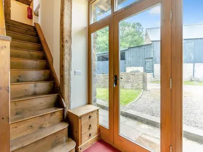 a wooden door leading to a staircase in a house at Wern Farm Barn in Cwmdu