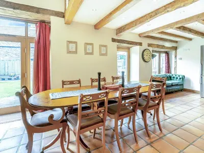 a dining room with a table and chairs at Wern Farm Barn in Cwmdu