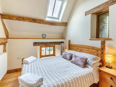 a bedroom with a bed and a window at Wern Farm Barn in Cwmdu