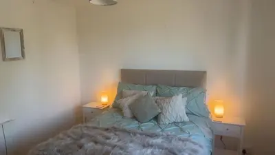 a bedroom with a bed with two lamps on the sides at Mountain View, Brecon Beacons