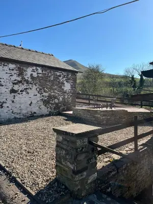 a stone building with a bench next to a fence at Mountain View, Brecon Beacons