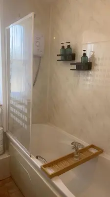 a bathroom with a bath tub with a sink at Mountain View, Brecon Beacons