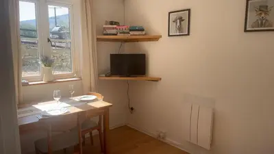 a room with a table and a television and a window at Mountain View, Brecon Beacons