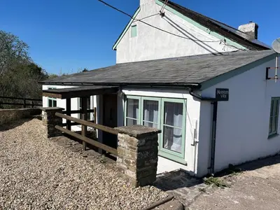 a white house with a wooden fence and a porch at Mountain View, Brecon Beacons
