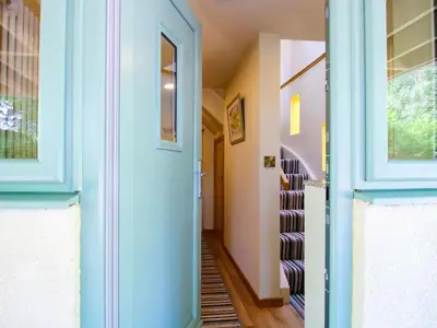 a hallway with a blue door and stairs at The Hideaway in Shrewsbury