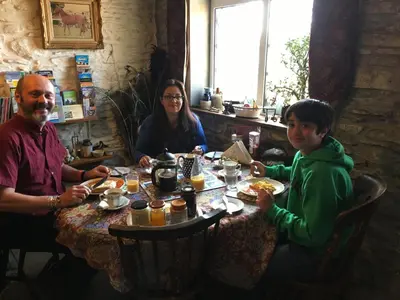 a group of people sitting at a table eating food at Five Saints Farmhouse B&B in Pumpsaint