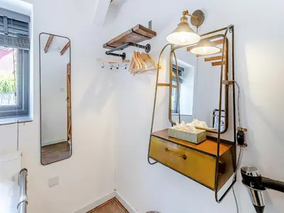 a mirror on a wall next to a vanity in a bathroom at The Old Cowsheds 5 - Llanilar - Uk49790 in Cribyn