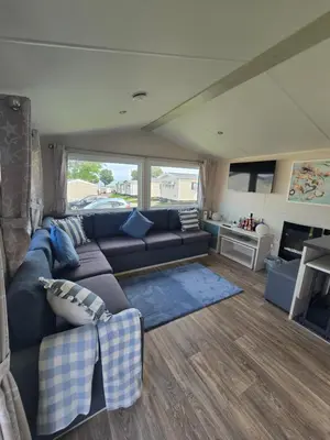 a living room with a couch and a tv at 6 Birth Caravan Quay West Sea Views in New Quay