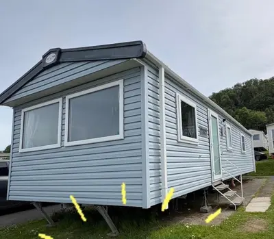 a gray tiny house is parked in a yard at 6 Birth Caravan Quay West Sea Views in New Quay