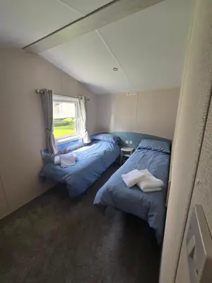 two beds in a small room with a window at 6 Birth Caravan Quay West Sea Views in New Quay
