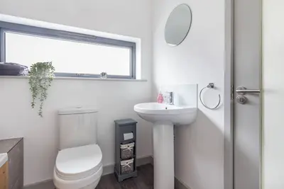 a white bathroom with a toilet and a sink at Zest Homes 87b Bridge Street in Leominster