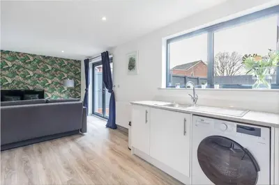 a kitchen with a sink and a washing machine at Zest Homes 87b Bridge Street in Leominster